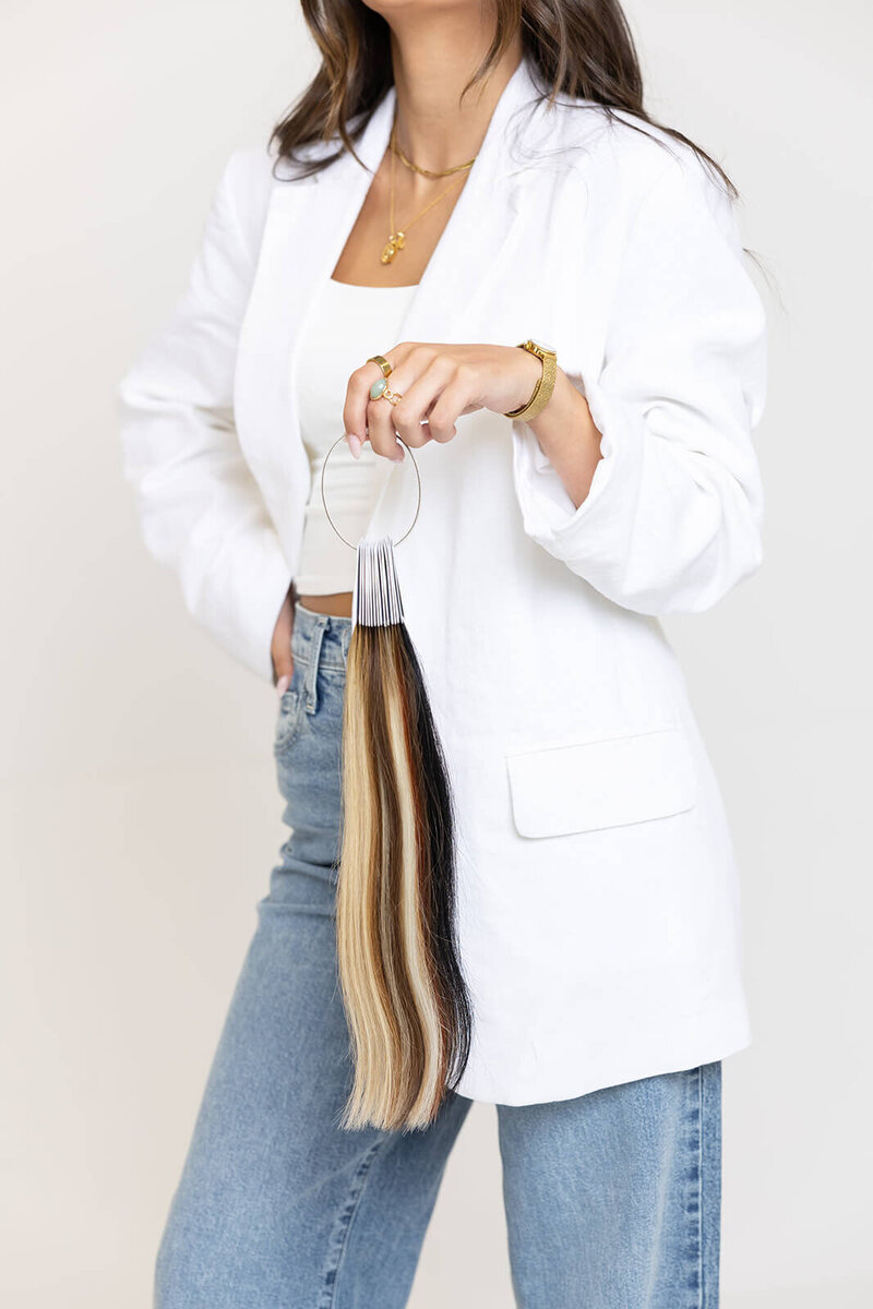 long-island-hair-stylist-in-white-jacket-and-blue-jeans-holding-hair-extensions-BFC-11