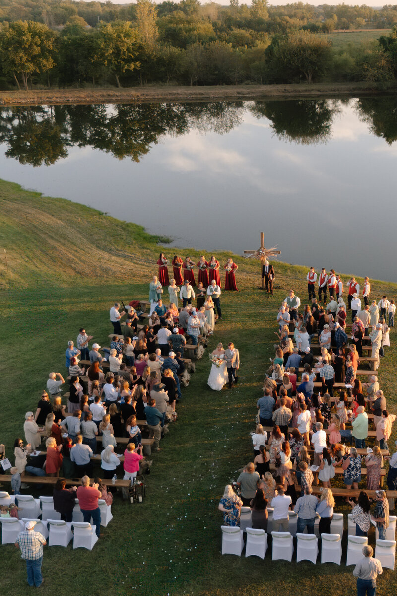 drone photo of bride and groom walking out of their OKC wedding ceremony