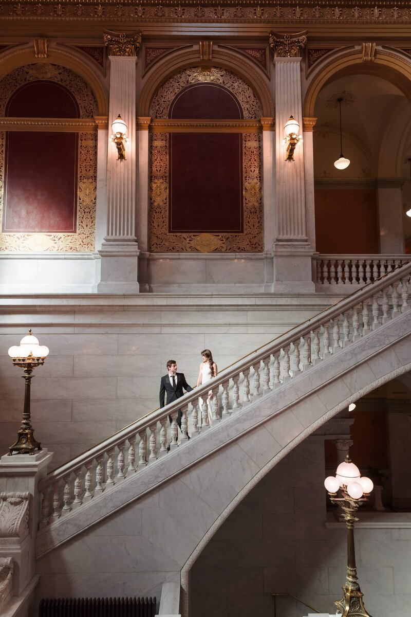 A young man leads his fiance down the steps inside the Ohio Statehouse