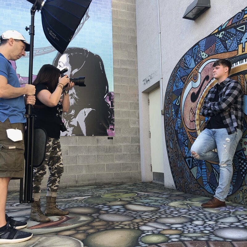 Photo shoot of senior boy leaning against graffiti wall