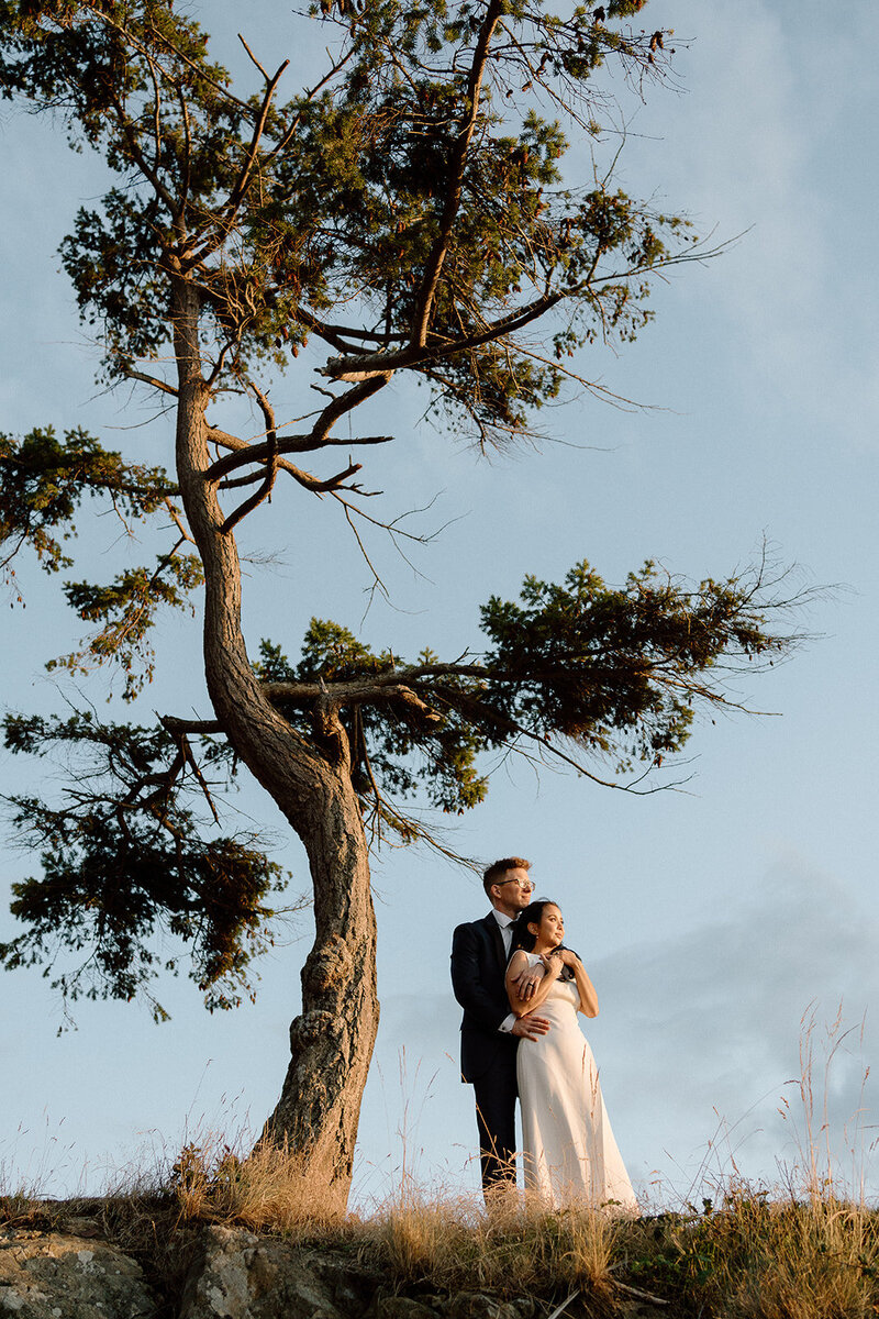 Vancouver wedding photographer captures  friends looking at bride and groom exchange rings during ceremony at Bloedel Conservatory