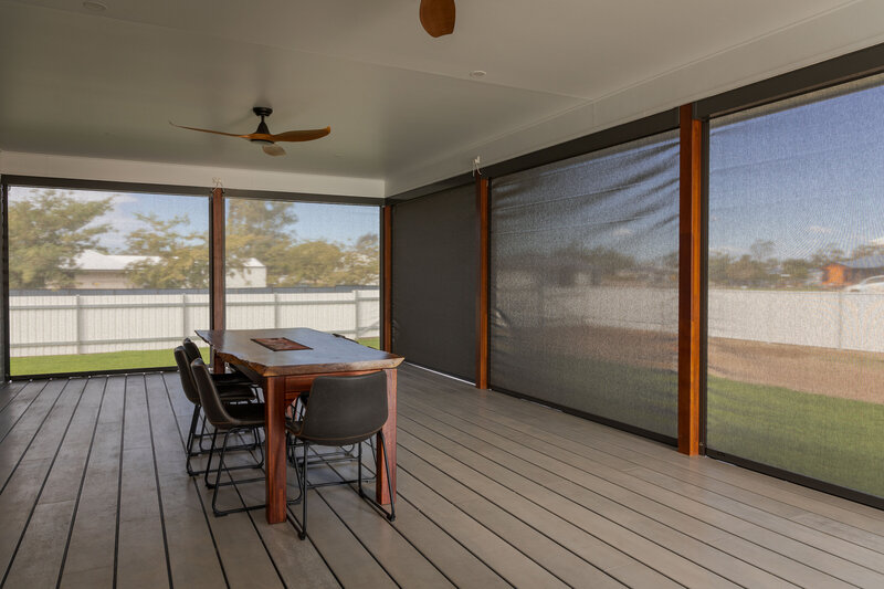 Outdoor patio with durable roller blinds, providing shade and privacy for alfresco living spaces.