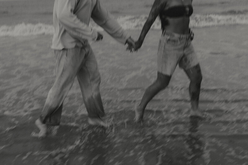 blurry photo of couples holding hands and running along the beach in jacksonville, florida