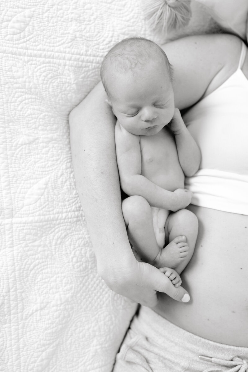 Birth photography in black and white with mother holding sleeping newborn baby