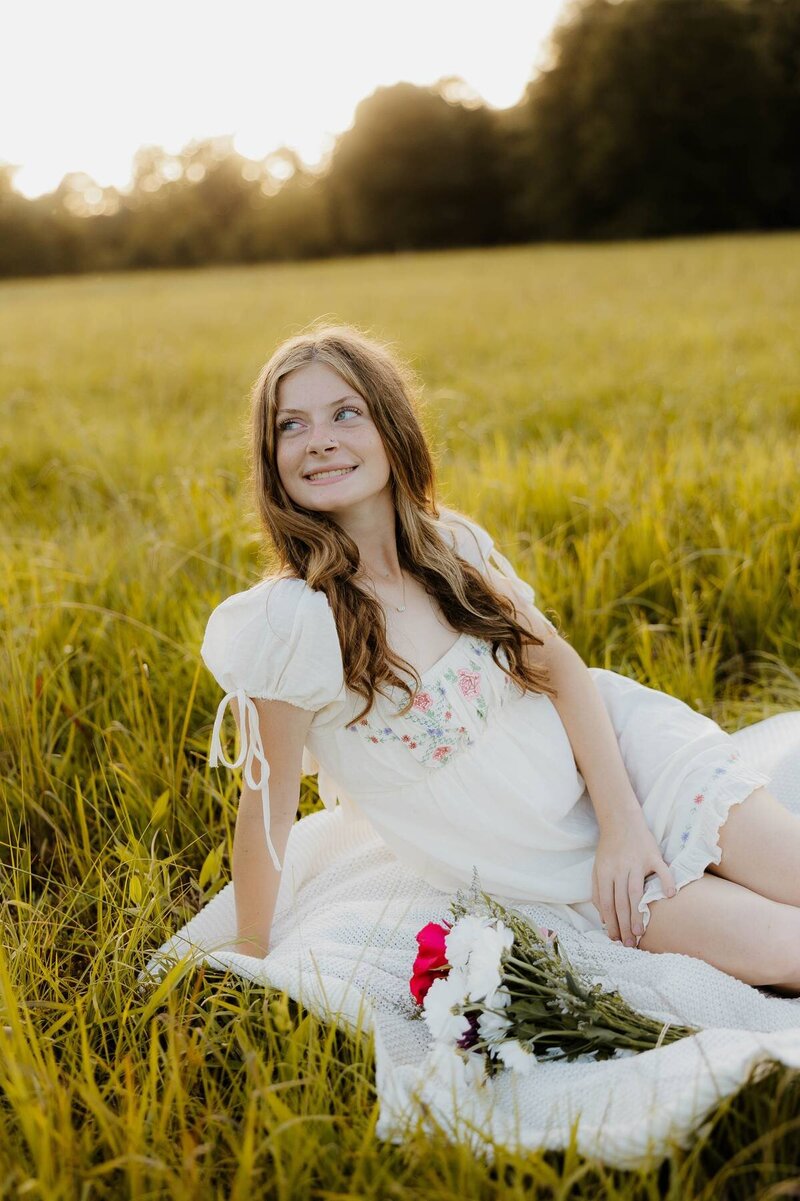 young senior girl sitting in grass smiling