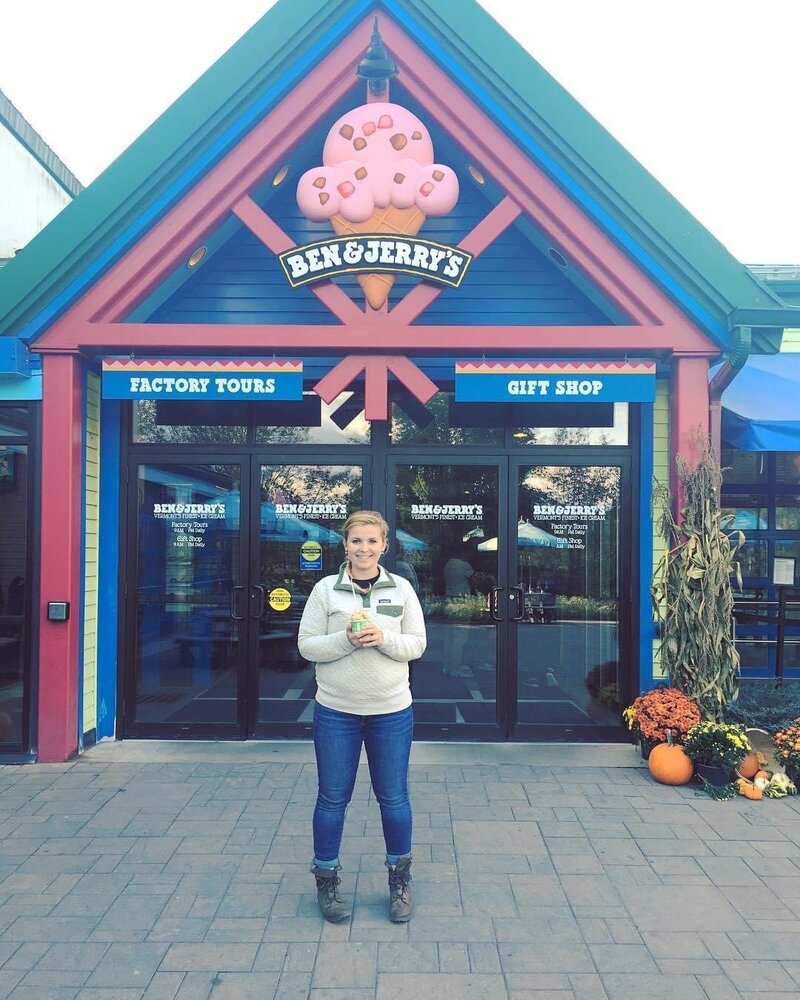 woman holding ice cream in front of ben and jerrys