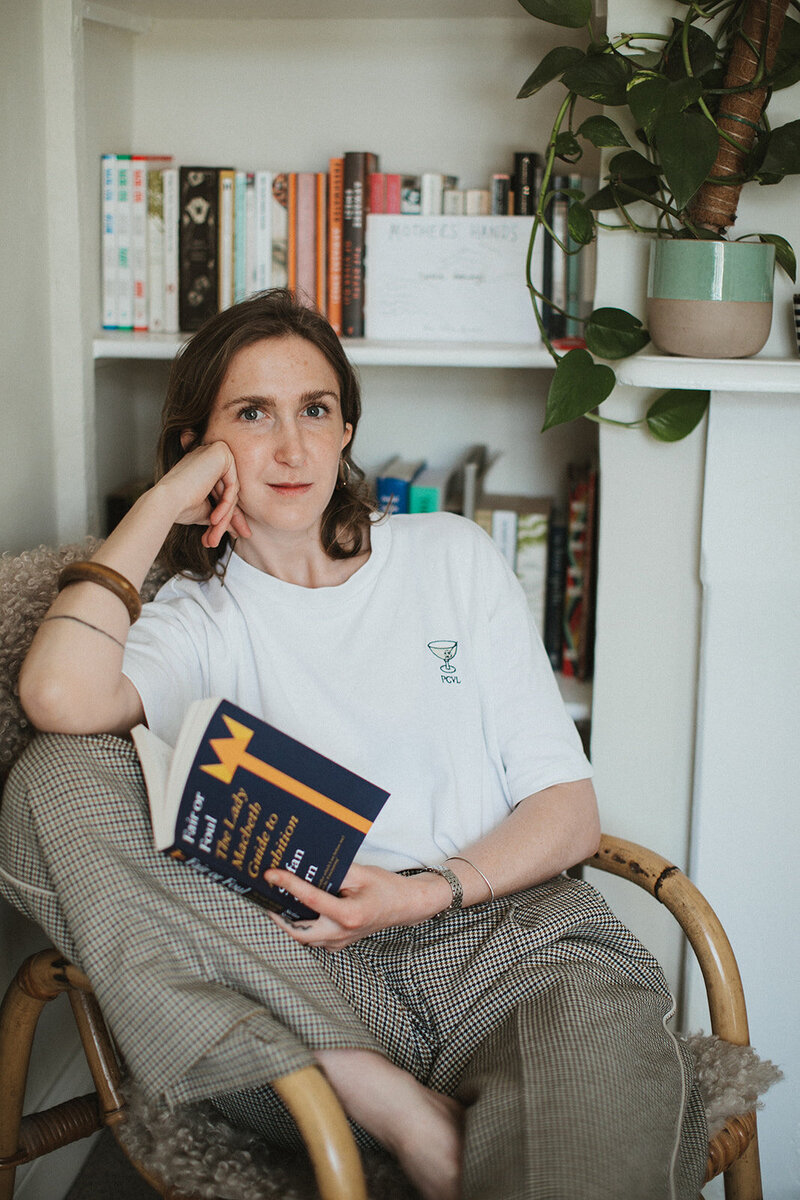 business coach in her office reading a book about ambition for women 