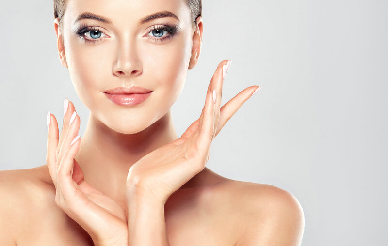Woman with clear skin and big blue eyes posing with hands