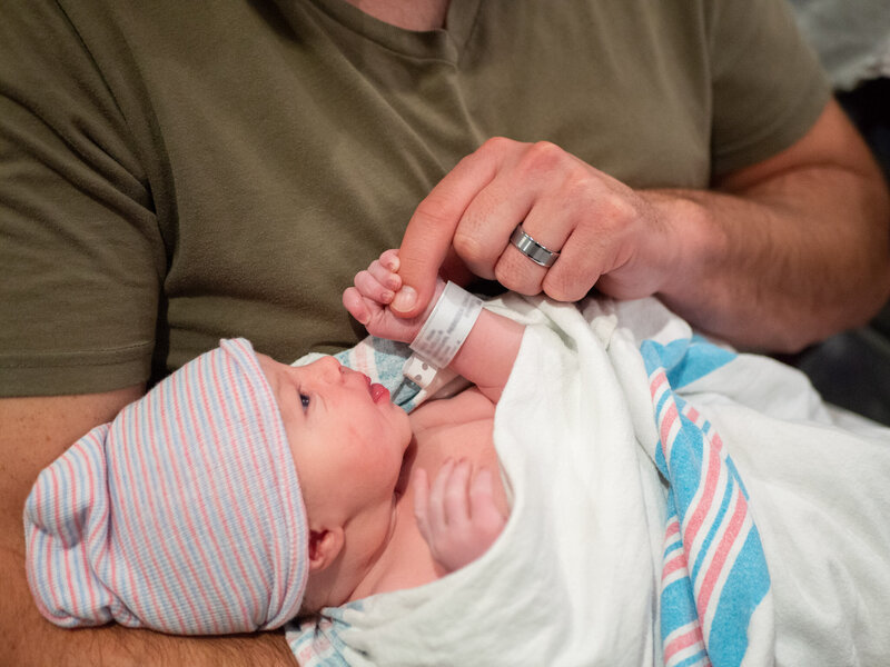 a new dad holds his new infant at Evergreen hospital captured by Seattle Birth Photographer, Becky Langseth.