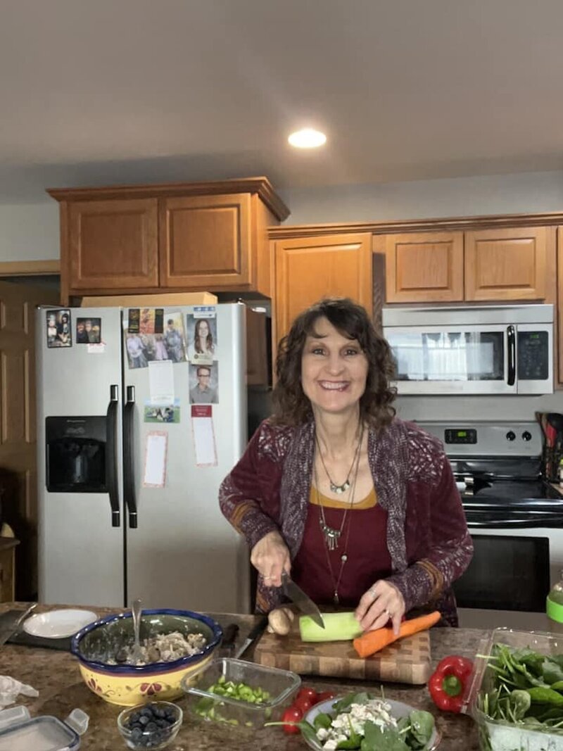 Penny cutting vegetables in her kitchen