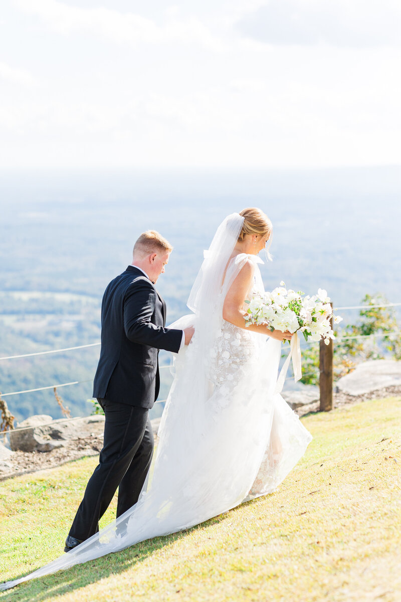 Bride and groom walking with mountain view at the cliffs at glassy