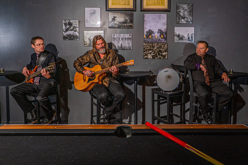 a band sitting in hightop chairs playing together 