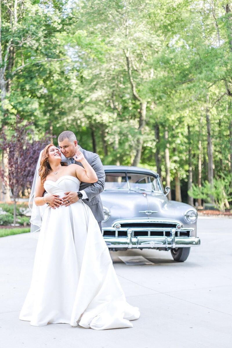 Bride and groom sharing a tender moment in a lush garden setting.