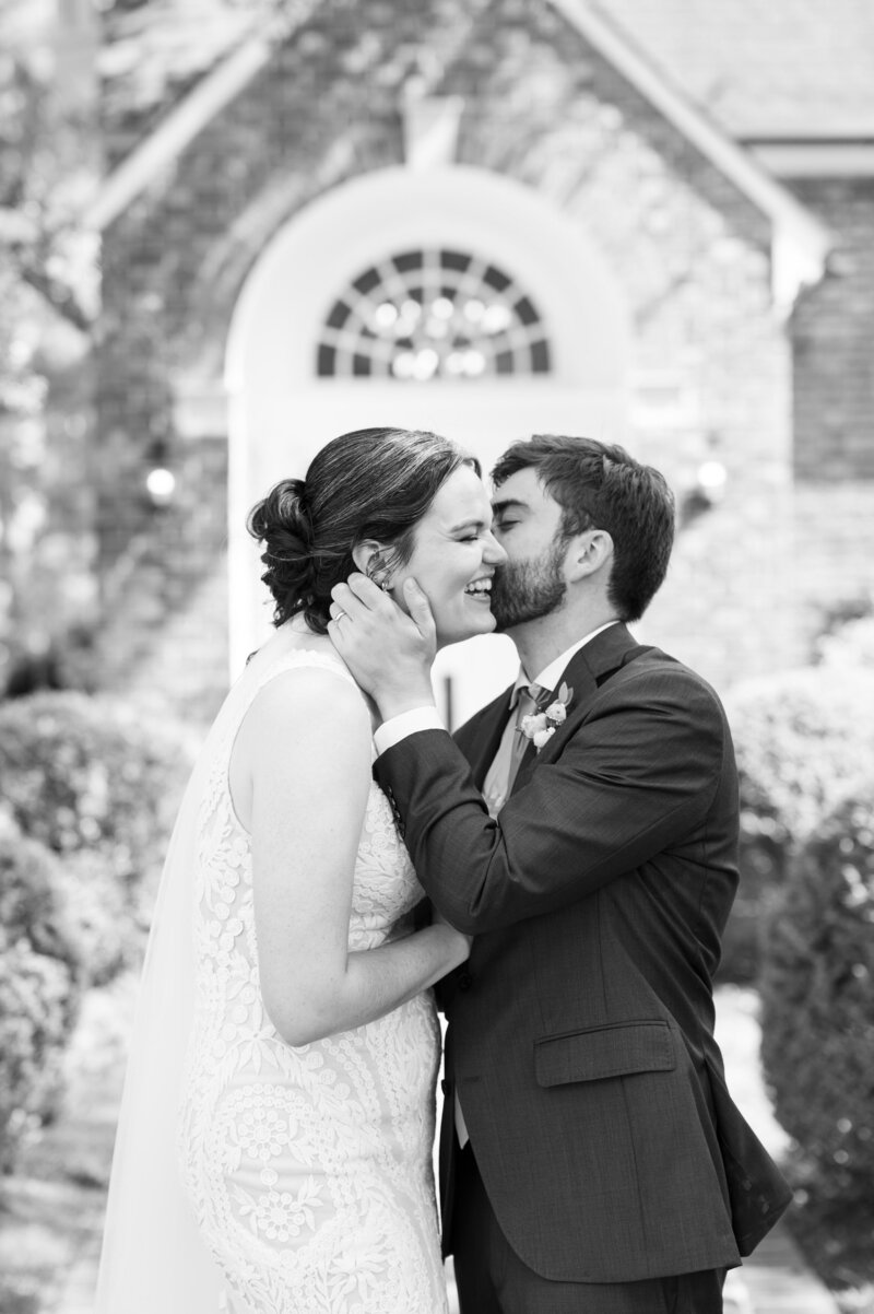 A person kissing their partner on the cheek on their wedding day