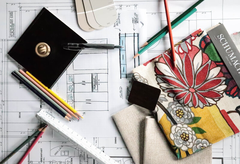 Interior design and remodeling plans with fabric swatches, blueprints, and design tools, showcasing home renovation and transformation planning.