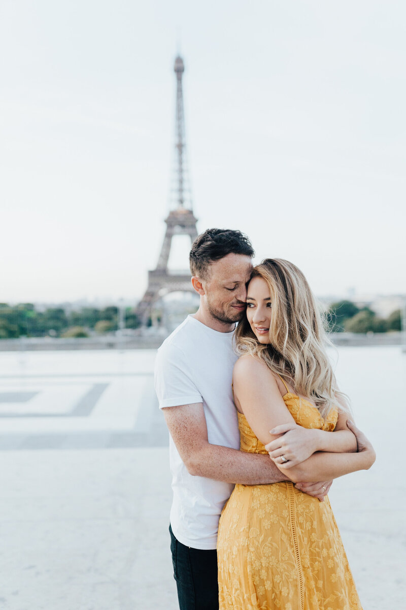 couple embracing in front of Eifel Tower