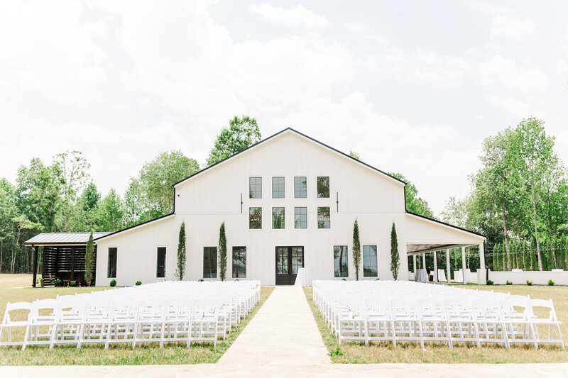 a white wedding venue staged for an outdoor ceremony