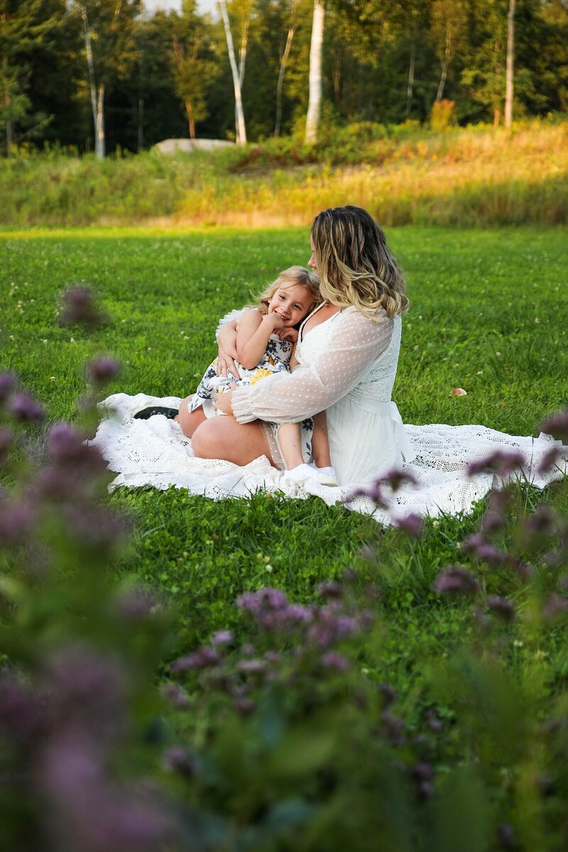 Mom sitting on a blanket holding her daughter | Family Photography Shoot
