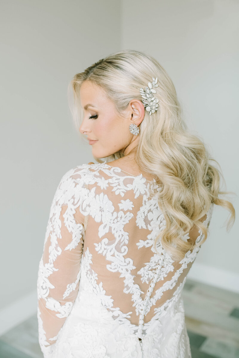 Gorgeous blond bride looks over her shoulder in gorgeous wedding dress