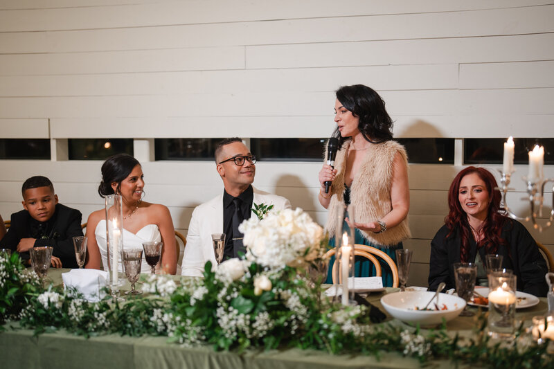 this matron of honor shares encouraging words with the bride and groom at their wedding