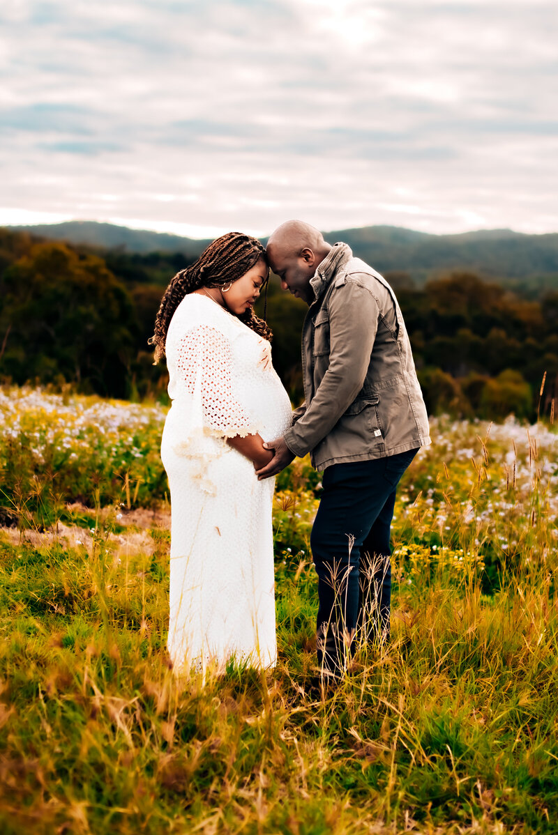 Captured in the heart of Brisbane's lush parklands, this family photo by Paula Jane Photography radiates joy and togetherness. Surrounded by the vibrant greenery of Roma St Parklands, the family shares laughter and embraces.