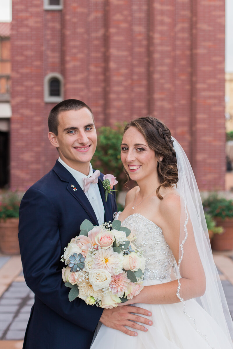 Bride and groom smiling and posing at Disney