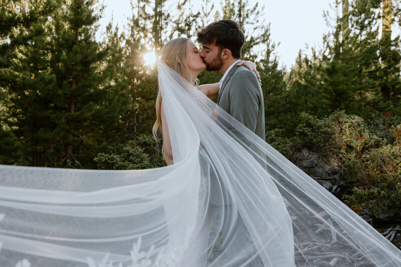 Bride holding her groom close as the sun sets over the Colorado mountains
