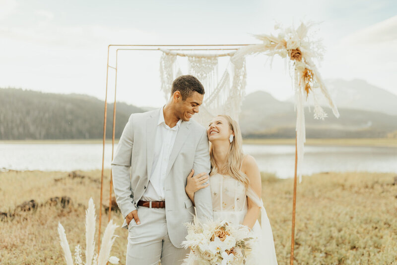 bride and groom holding each other by the coast