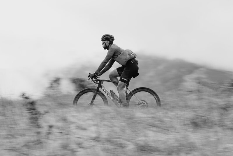 black and white photo of man mountain biking