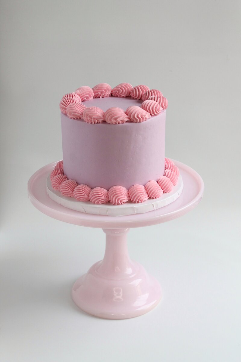 Pink cake with frosting and gold butterflies