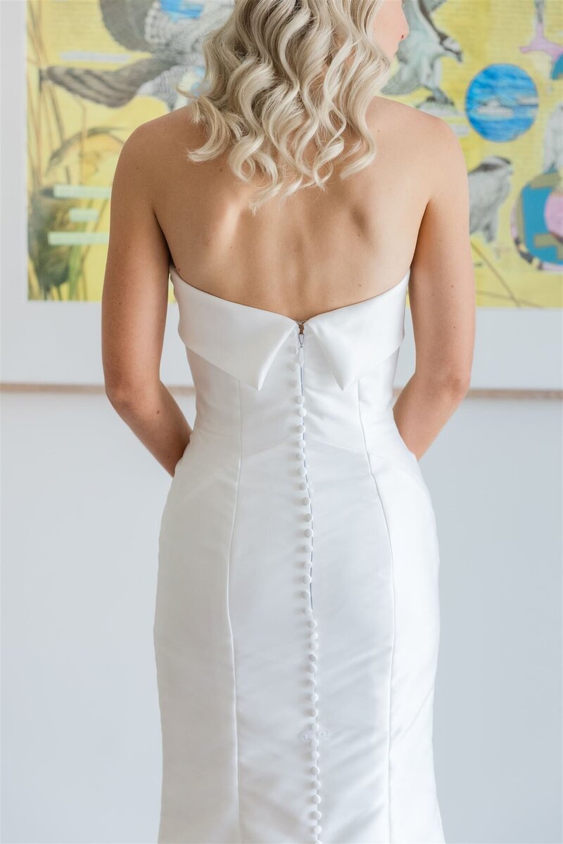 A closeup photo of the bride's dress buttons going down her back at the Alfond Inn.