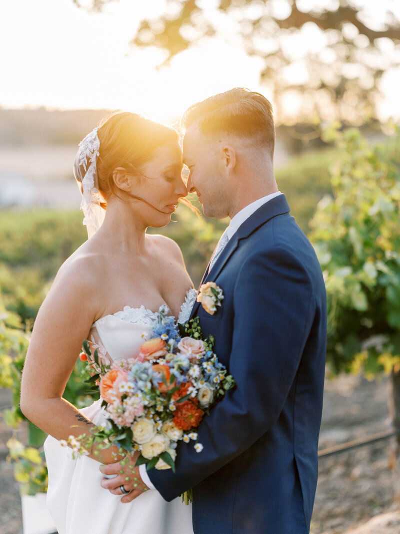 Bride and groom, kissing in the sunset during their luxury Vineyard wedding in San Luis Obispo, California