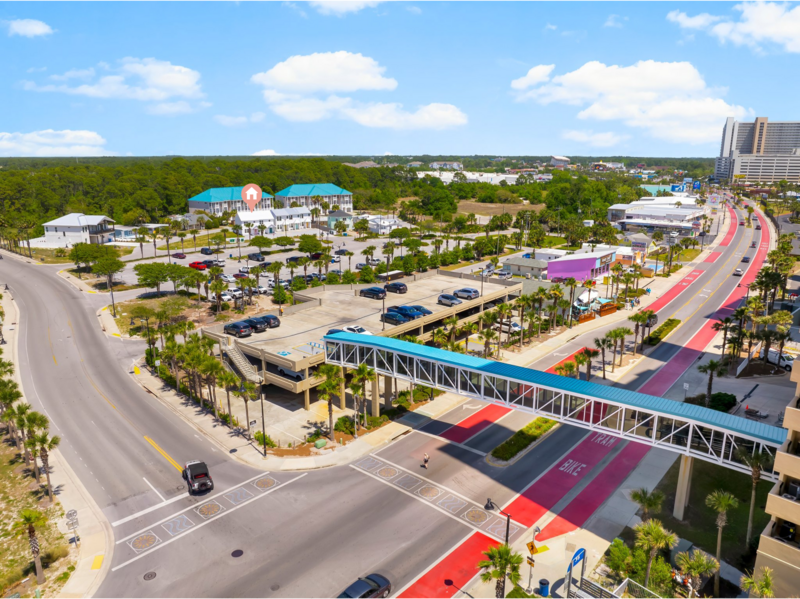 Aerial view showing the Pink Door's close proximity to the beach overpass and vibrant Front Beach Road in Panama City Beach, FL.