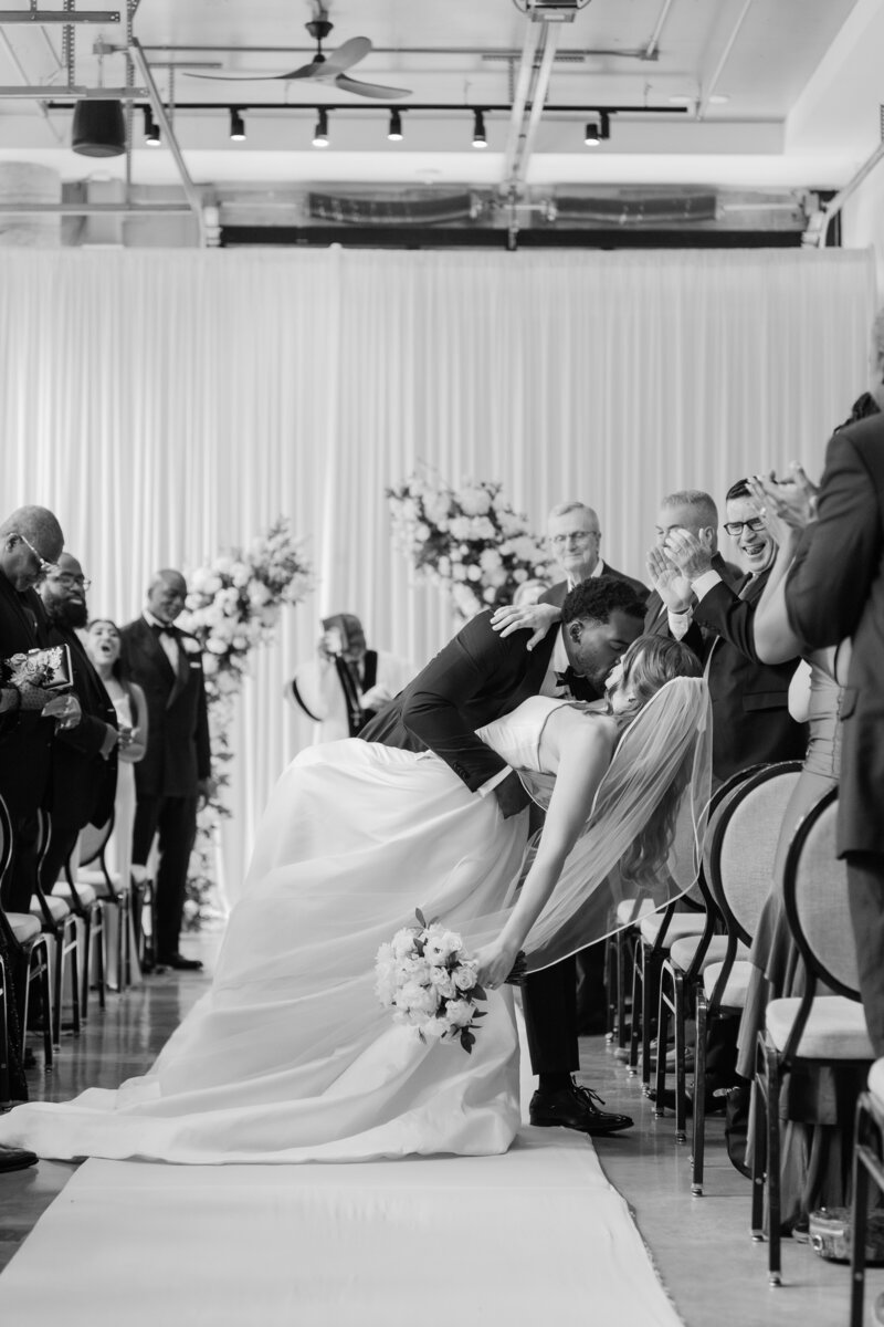A wedding ceremony kiss between a bride and groom in a black and white photo at the Ben, Autograph Collection in West Palm Beach.