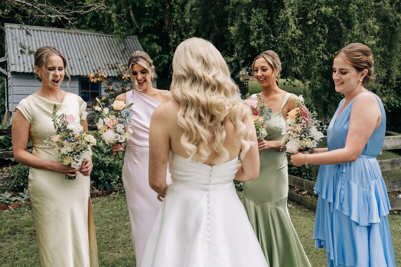 bridesmaids in mismatching pastel dresses with pastel florals in gore southland at a wedding