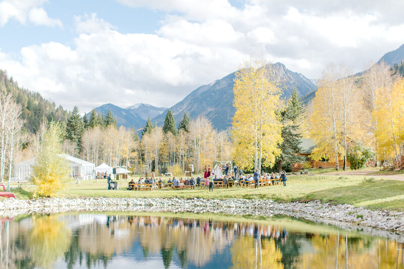 A Colorado bride carries a bouquet of pink and white flowers at her wedding.