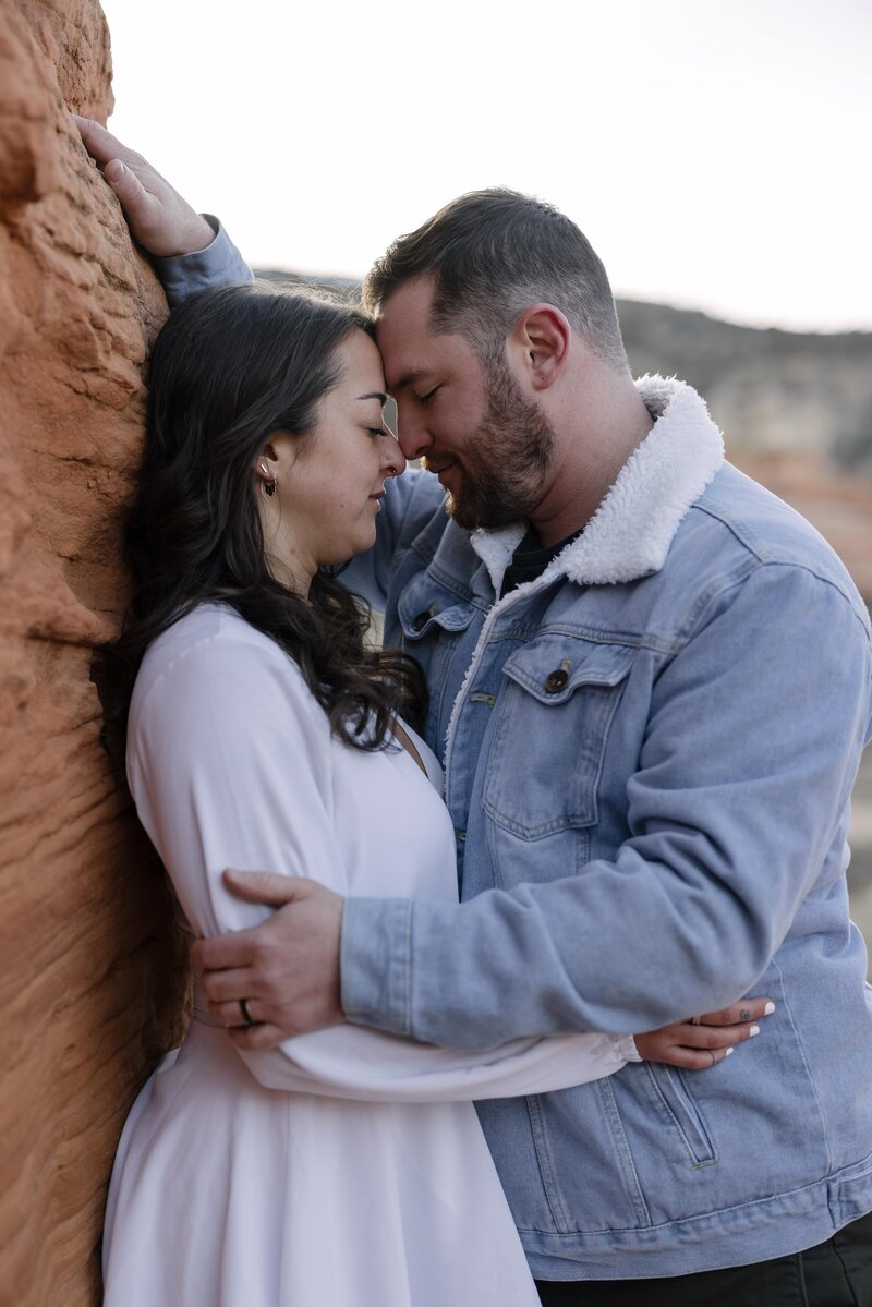 intimate engagement photos against red rock formations in Wyoming
