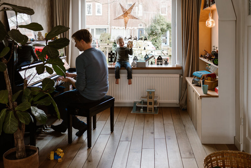 gezinssfoto, vader speelt piano en kind luistert