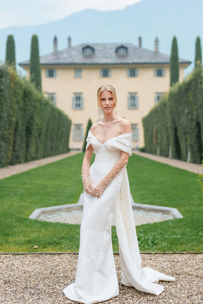 bride standing in front of large estate home