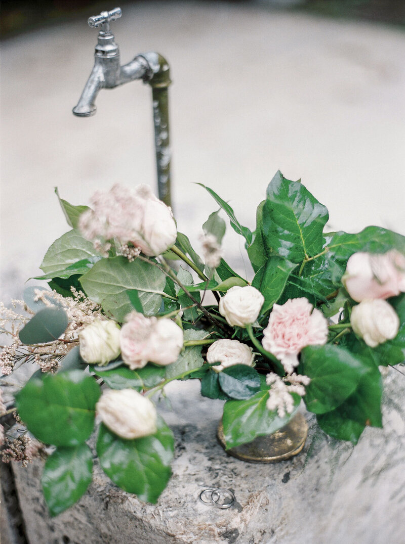 A vintage floral collection with roses, carnations, and lush greenery in antique vases.
