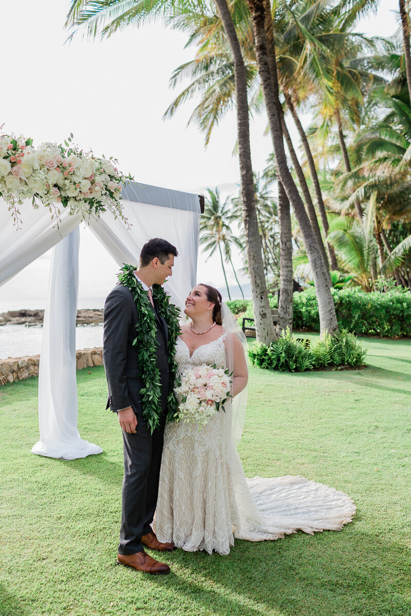 Disney wedding of couple on beach with palm trees