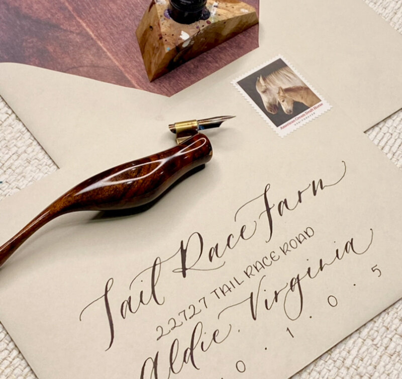 envelope with custom calligraphy with the calligraphy pen on top