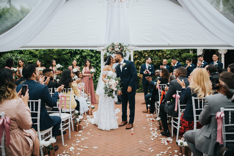 A beautiful ceremony held in the Gardens Courtyard under a beautiful tent.