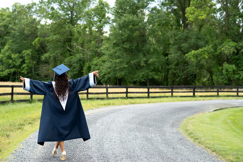 girl  in cap and gown arms outstretched