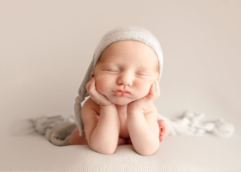 Baby laying in heart shape bowl in newborn shoot.