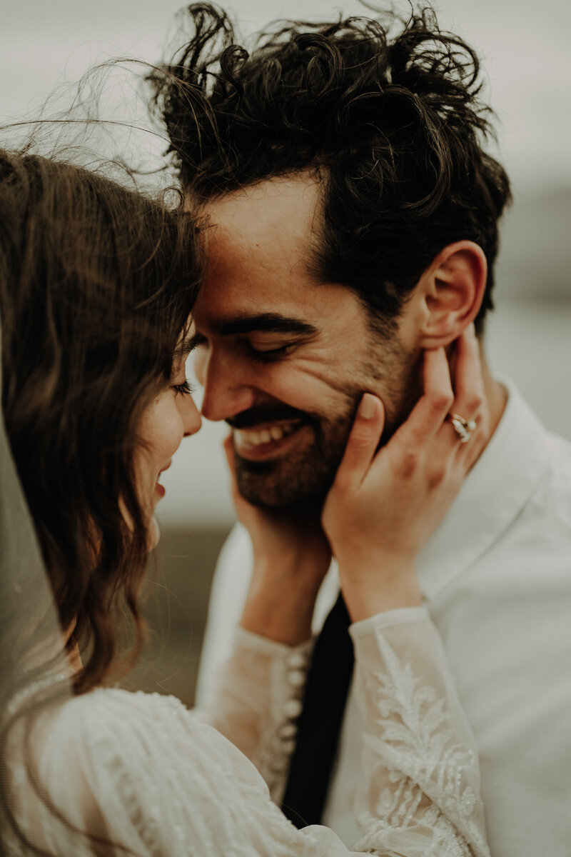 bride holding grooms face and they touch noses and look lovingly into each other eyes emotional alternative wedding photographer scotland