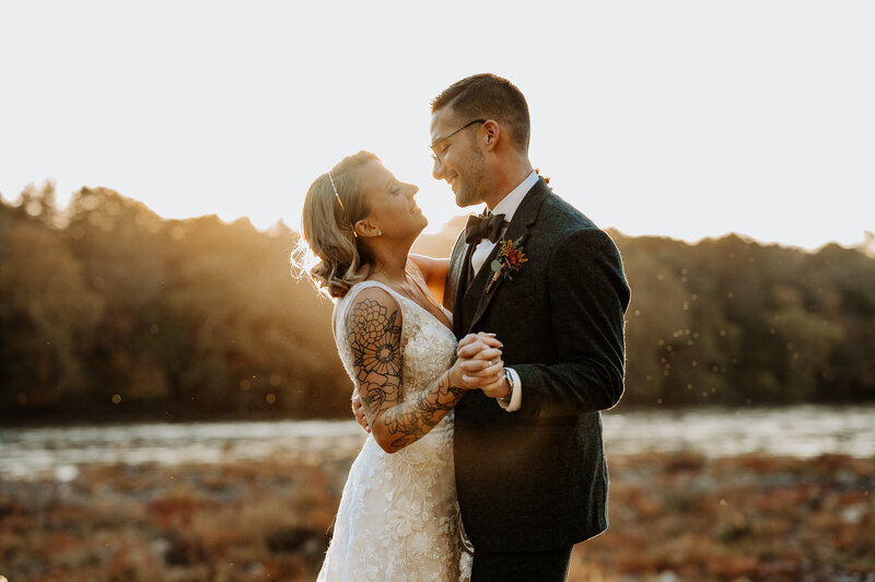 bride and groom at sunset holding hands and dancing