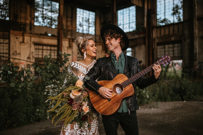 Bride and groom holding guitar and laughing