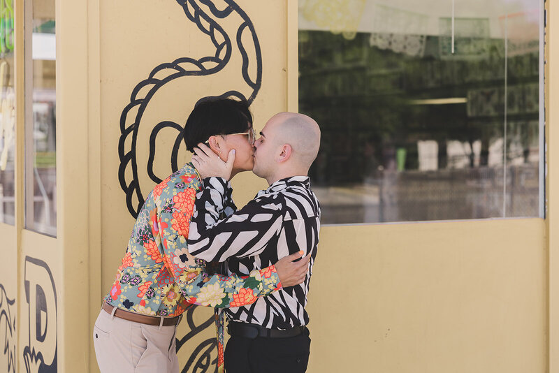 LGBTQ+ couple kiss before their elopement ceremony at a tattoo shop in las vegas
