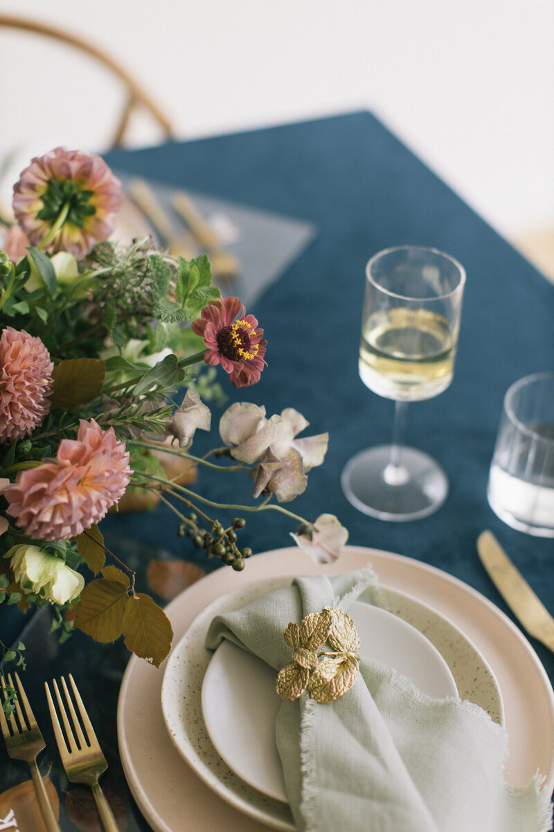 A garden-inspired table centerpiece and place setting brimming with mauve flowers.